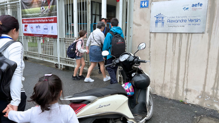 Photographie de parents accompagnant leurs enfants au lycée français Alexandre Yersin d'Hanoï (Vietnam)