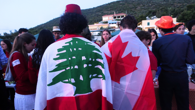 Photographie de deux élèves du réseau, l'un portant sur son dos le drapeau du Liban, l'autre du Canada.